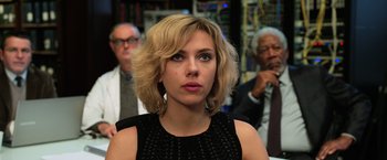 Movie still from “Lucy” (2014), directed by Luc Besson – A person wearing a black dress; Close Up shot, Over the shoulder angle