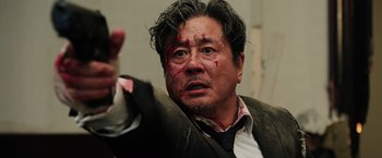 Movie still from “Lucy” (2014), directed by Luc Besson – A person wearing a suit and tie; Close Up shot, Low angle