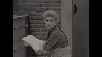 Movie still from “Lucy and Desi” (2022), directed by Amy Poehler – A black - and - white photo of a woman holding a piece of paper; Medium shot, High angle