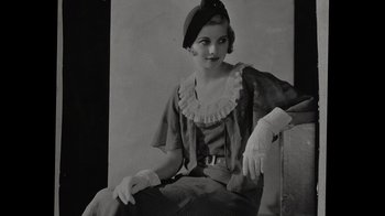 Movie still from “Lucy and Desi” (2022), directed by Amy Poehler – An old photo of a woman sitting on a chair; Medium shot, Low angle