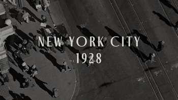 Movie still from “Lucy and Desi” (2022), directed by Amy Poehler – An aerial view of people walking down a street; Extreme Wide shot, Overhead angle