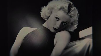 A black and white photo of a woman in a black dress