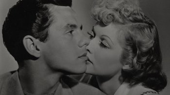 Movie still from “Lucy and Desi” (2022), directed by Amy Poehler – A black and white photo of a man and a woman kissing; Close Up shot, Overhead angle