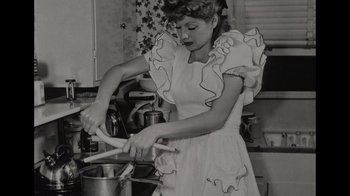 Movie still from “Lucy and Desi” (2022), directed by Amy Poehler – An old photo of a woman stirring a pot; Medium shot, High angle