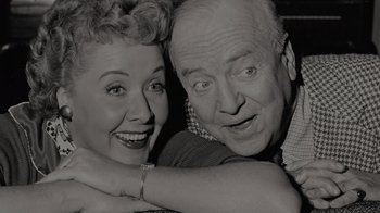 Movie still from “Lucy and Desi” (2022), directed by Amy Poehler – An older man and a younger woman posing for a picture; Close Up shot, High angle