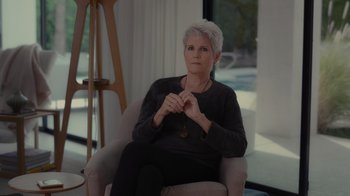 Movie still from “Lucy and Desi” (2022), directed by Amy Poehler – An older woman sitting in a chair in front of a window; Medium shot, Low angle