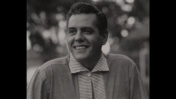 Movie still from “Lucy and Desi” (2022), directed by Amy Poehler – An old photo of a man smiling for the camera; Close Up shot, Low angle
