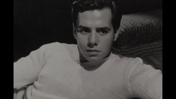 Movie still from “Lucy and Desi” (2022), directed by Amy Poehler – Black and white photograph of a man in a sweater; Close Up shot, High angle