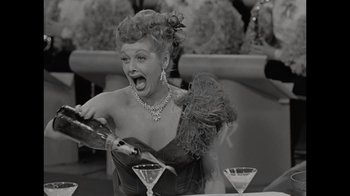 Movie still from “Lucy and Desi” (2022), directed by Amy Poehler – An old photo of a woman holding a wine bottle; Close Up shot, High angle