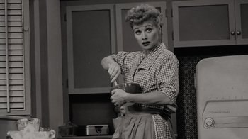 Movie still from “Lucy and Desi” (2022), directed by Amy Poehler – A black - and - white photo of a woman stirring a bowl; Medium shot, High angle