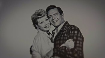 Movie still from “Lucy and Desi” (2022), directed by Amy Poehler – An old black and white photo of a man and a woman hugging; Extreme Close Up shot, Overhead angle