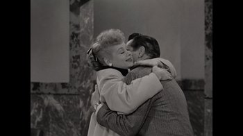 Movie still from “Lucy and Desi” (2022), directed by Amy Poehler – An old black and white photo of a man and a woman hugging; Medium shot, High angle