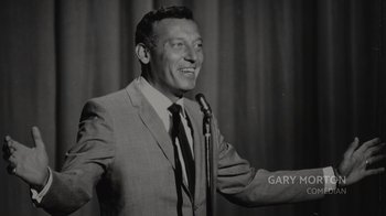 Movie still from “Lucy and Desi” (2022), directed by Amy Poehler – An old photo of a man in a suit holding a microphone; Close Up shot, Low angle
