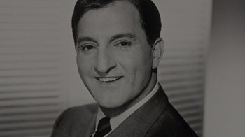 Movie still from “Lucy and Desi” (2022), directed by Amy Poehler – Black and white photograph of a man in a suit and tie; Close Up shot, Low angle