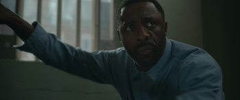 Movie still from “Luther: The Fallen Sun” (2023), directed by Jamie Payne – A person in a room near a window; Close Up shot, High angle