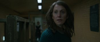 Movie still from “Luther: The Fallen Sun” (2023), directed by Jamie Payne – A woman in a green sweater looking at the camera; Close Up shot, Over the shoulder angle