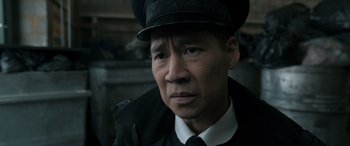 Movie still from “Luther: The Fallen Sun” (2023), directed by Jamie Payne – A man wearing a black hat and a white shirt; Close Up shot, Over the shoulder angle