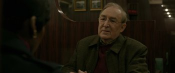 Movie still from “Luther: The Fallen Sun” (2023), directed by Jamie Payne – An older man sitting in front of a mirror; Close Up shot, Over the shoulder angle