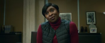 Movie still from “Luther: The Fallen Sun” (2023), directed by Jamie Payne – A woman sitting in a chair wearing a vest; Close Up shot, Over the shoulder angle