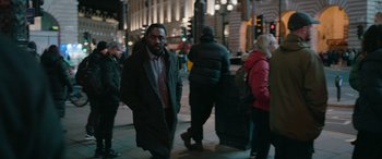 Movie still from “Luther: The Fallen Sun” (2023), directed by Jamie Payne – A man is walking down the street at night; Medium shot, Over the shoulder angle