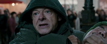 Movie still from “Luther: The Fallen Sun” (2023), directed by Jamie Payne – A person wearing a hooded jacket; Close Up shot, Over the shoulder angle