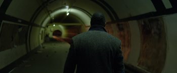 Movie still from “Luther: The Fallen Sun” (2023), directed by Jamie Payne – A man in a jacket is walking in a tunnel; Medium shot, Low angle