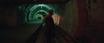 Movie still from “Luther: The Fallen Sun” (2023), directed by Jamie Payne – A man standing in the middle of an underground tunnel; Wide shot, High angle