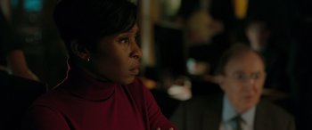 Movie still from “Luther: The Fallen Sun” (2023), directed by Jamie Payne – A woman in a red shirt is sitting down; Close Up shot, Over the shoulder angle