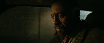Movie still from “Luther: The Fallen Sun” (2023), directed by Jamie Payne – A person looking out a car window; Close Up shot, Low angle