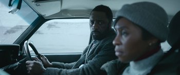 Movie still from “Luther: The Fallen Sun” (2023), directed by Jamie Payne – A man and a woman sitting in the back of a car; Close Up shot, Over the shoulder angle