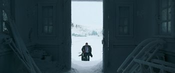 Movie still from “Luther: The Fallen Sun” (2023), directed by Jamie Payne – A man sitting on a chair in the snow; Extreme Wide shot, High angle