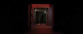 Movie still from “Luther: The Fallen Sun” (2023), directed by Jamie Payne – A man standing in a dark tunnel with lights on; Extreme Wide shot, Low angle