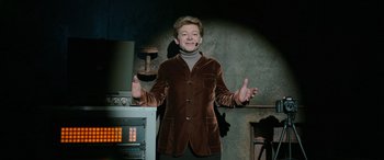 Movie still from “Luther: The Fallen Sun” (2023), directed by Jamie Payne – A man in a brown jacket is standing in front of an oven; Medium shot, Low angle