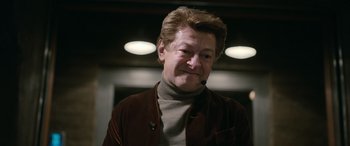 Movie still from “Luther: The Fallen Sun” (2023), directed by Jamie Payne – A person wearing a brown jacket; Close Up shot, Over the shoulder angle