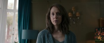 Movie still from “Luther: The Fallen Sun” (2023), directed by Jamie Payne – A woman with long brown hair wearing a blue sweater; Close Up shot, Over the shoulder angle