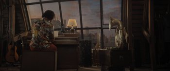 Movie still from “Lyle, Lyle, Crocodile” (2022), directed by Will Speck – A woman sitting at a desk in front of a large window; Extreme Wide shot, High angle