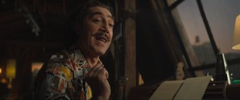 Movie still from “Lyle, Lyle, Crocodile” (2022), directed by Will Speck – A man with a mustache is holding his hand up to his chin; Close Up shot, Low angle