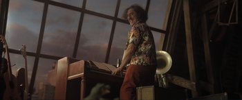 Movie still from “Lyle, Lyle, Crocodile” (2022), directed by Will Speck – A man standing next to an organ in front of a large window; Medium shot, Low angle