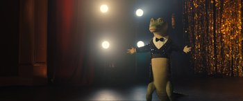 Movie still from “Lyle, Lyle, Crocodile” (2022), directed by Will Speck – A frog dressed in a suit and bow tie; Wide shot, Low angle