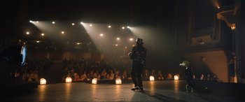 Movie still from “Lyle, Lyle, Crocodile” (2022), directed by Will Speck – A man wearing a top hat standing in front of an audience; Extreme Wide shot, Over the shoulder angle