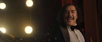 Movie still from “Lyle, Lyle, Crocodile” (2022), directed by Will Speck – A man with long hair wearing a black tuxedo; Close Up shot, Low angle