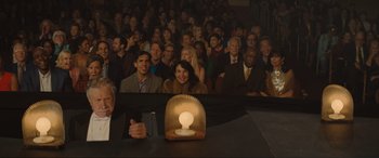 Movie still from “Lyle, Lyle, Crocodile” (2022), directed by Will Speck – A group of people sitting in front of an audience; Wide shot, High angle