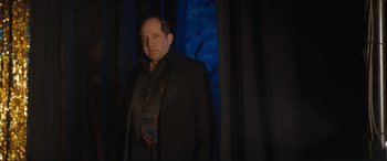 Movie still from “Lyle, Lyle, Crocodile” (2022), directed by Will Speck – A man in a black jacket standing in front of a window; Medium shot, Low angle