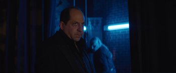 Movie still from “Lyle, Lyle, Crocodile” (2022), directed by Will Speck – A man standing in a dark room next to another man; Medium shot, Low angle