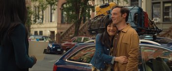 Movie still from “Lyle, Lyle, Crocodile” (2022), directed by Will Speck – A man and a woman hugging in front of a car; Medium shot, Low angle
