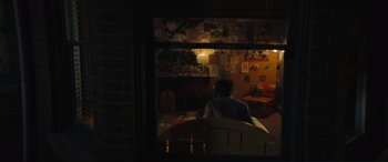 Movie still from “Lyle, Lyle, Crocodile” (2022), directed by Will Speck – A person sitting at a table in a room; Extreme Wide shot, High angle