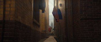 Movie still from “Lyle, Lyle, Crocodile” (2022), directed by Will Speck – An alleyway in an urban setting with clothes hanging on a clothesline; Extreme Wide shot, Low angle
