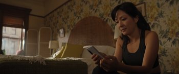 Movie still from “Lyle, Lyle, Crocodile” (2022), directed by Will Speck – A woman sitting on a bed looking at a tablet; Close Up shot, High angle