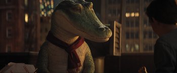 Movie still from “Lyle, Lyle, Crocodile” (2022), directed by Will Speck – A stuffed alligator wearing a red and white scarf; Medium shot, Over the shoulder angle