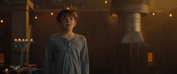 Movie still from “Lyle, Lyle, Crocodile” (2022), directed by Will Speck – A young man standing in a room with a brick wall; Medium shot, Low angle